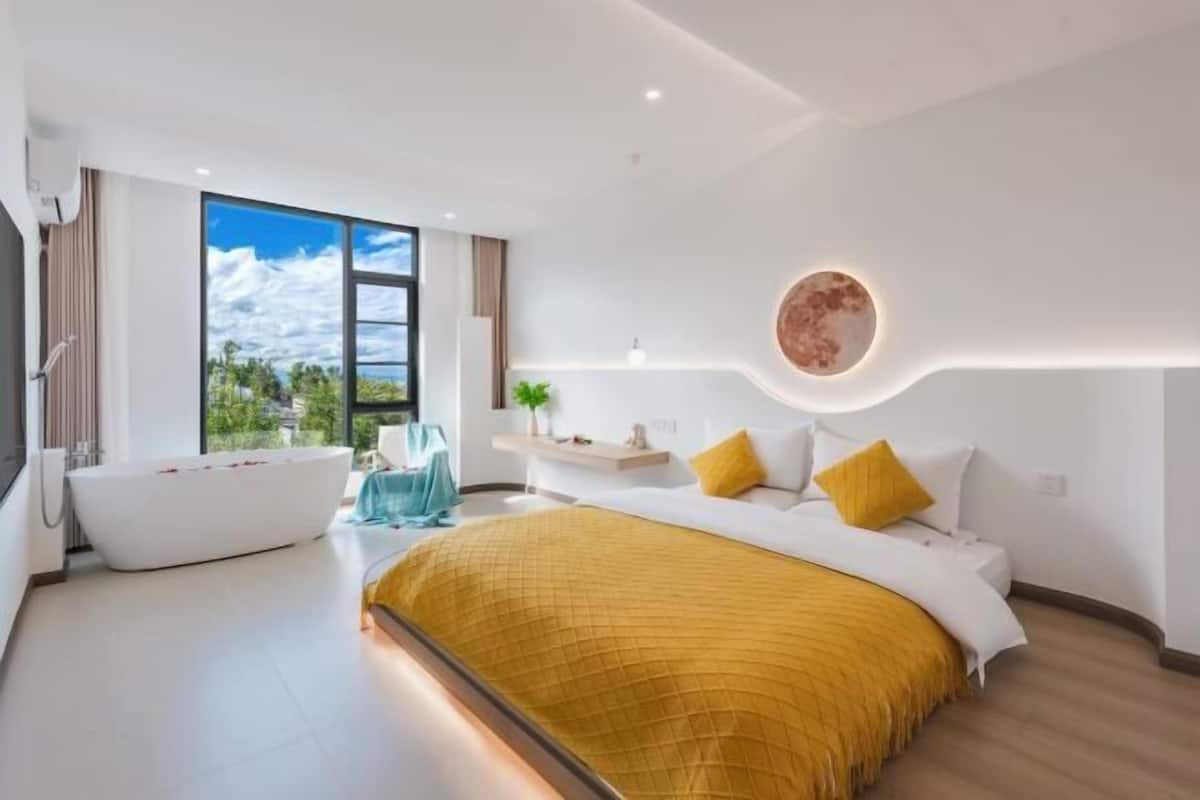 Un dormitorio moderno con una cama grande, una bañera y vistas al exterior.