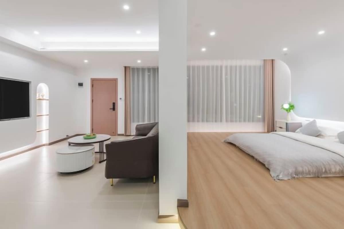 Une chambre d’hôtel moderne équipée d’un lit, d’un canapé, d’une petite table et d’un téléviseur.