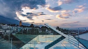 A modern building with a glass facade and a staircase leading to a rooftop. - First Sight Yingshan Resort (Dali)