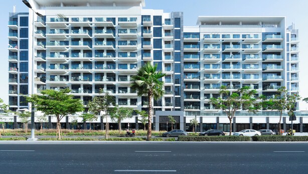 A modern multi-story hotel with balconies, a parking area, and palm trees. - Modern Studio in Azizi Riviera 46  (Dubai)