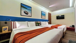 A hotel room with two beds, a TV, and a painting of a beach scene. - Joi Boutique Bãi Sau  (Ho Chi Minh City)