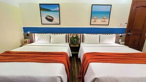 A hotel room with two beds, a wooden headboard, a nightstand with a vase of flowers, and two framed pictures on the wall. - Joi Boutique Bãi Sau  (Ho Chi Minh City)
