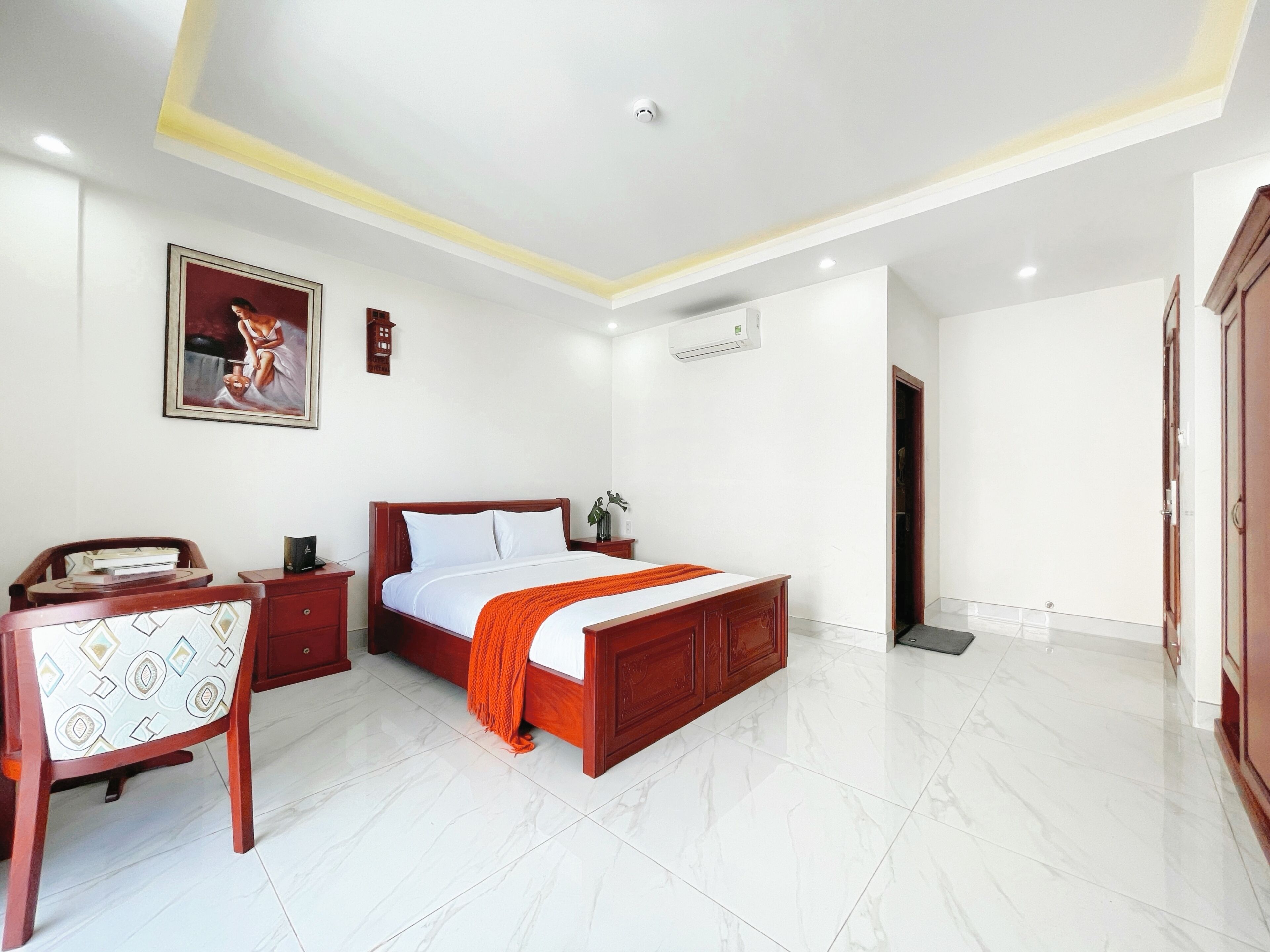 A bedroom with a bed, a desk, and a chair.