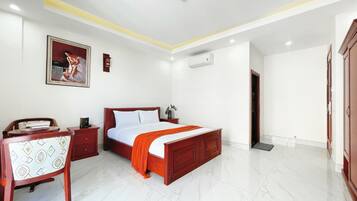 A bedroom with a bed, a desk, and a chair.