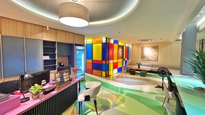 Una zona de recepción moderna con mostrador, computadora y área de estar.
