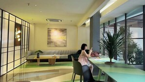 A modern interior with a sofa, a table, and a large window. - Joi Boutique Bãi Sau  (Ho Chi Minh City)
