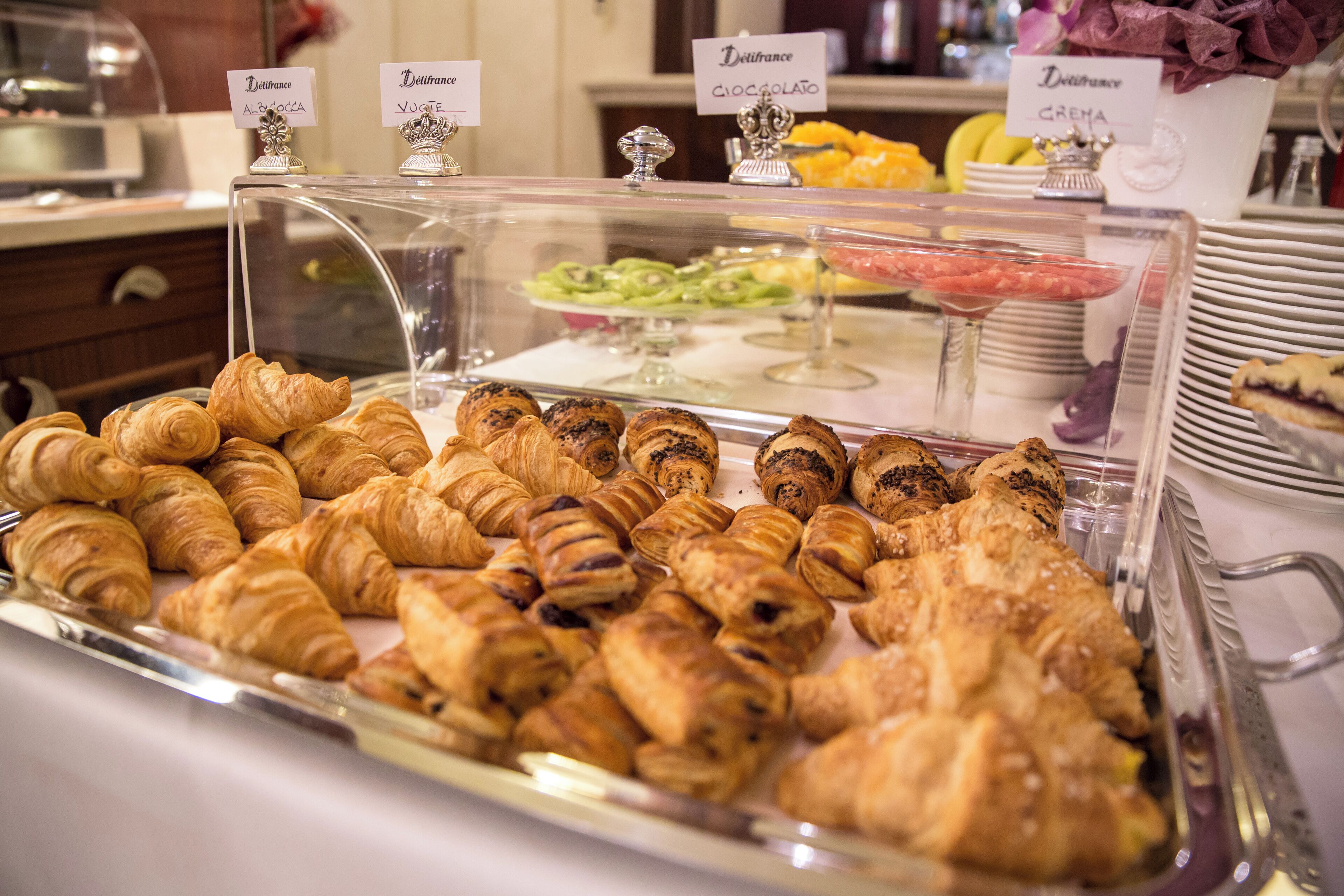 A bakery display with various pastries and a sign indicating different types of crepes.