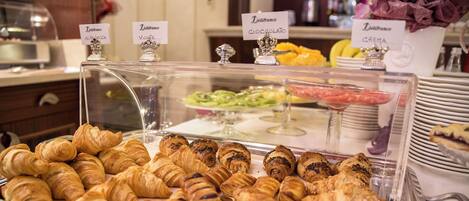 A bakery display with various pastries and a sign indicating different types of crepes.