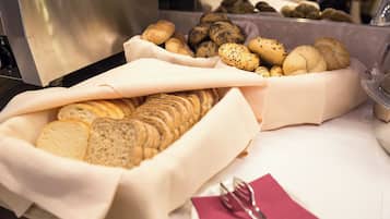 Un tavolo con una varietà di pane e dolci.