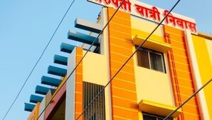 Ein Gebäude mit einem Schild in Hindi, einer Treppe und blauem Himmel.