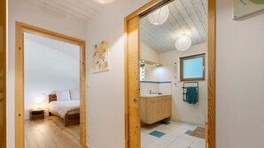 Un dormitorio con una cama, una mesita de noche y una lámpara en la pared.