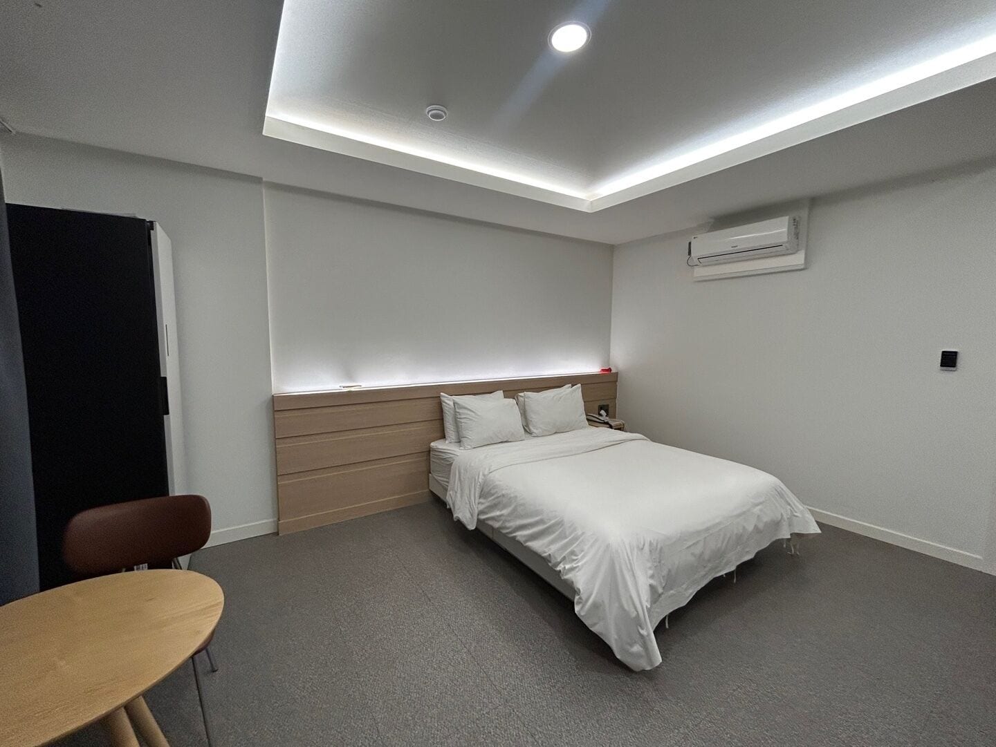 A modern hotel room with a bed, a desk, and a chair.
