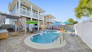 A backyard with a swimming pool, outdoor furniture, and a wooden deck. - Family Beach House w/ Pool & Game Room – Sleeps 14 (Panama City Beach)