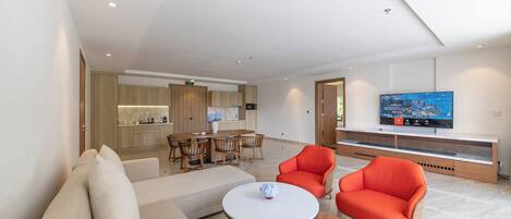 Una habitación de hotel moderna con sala de estar, una mesa de comedor y un televisor.