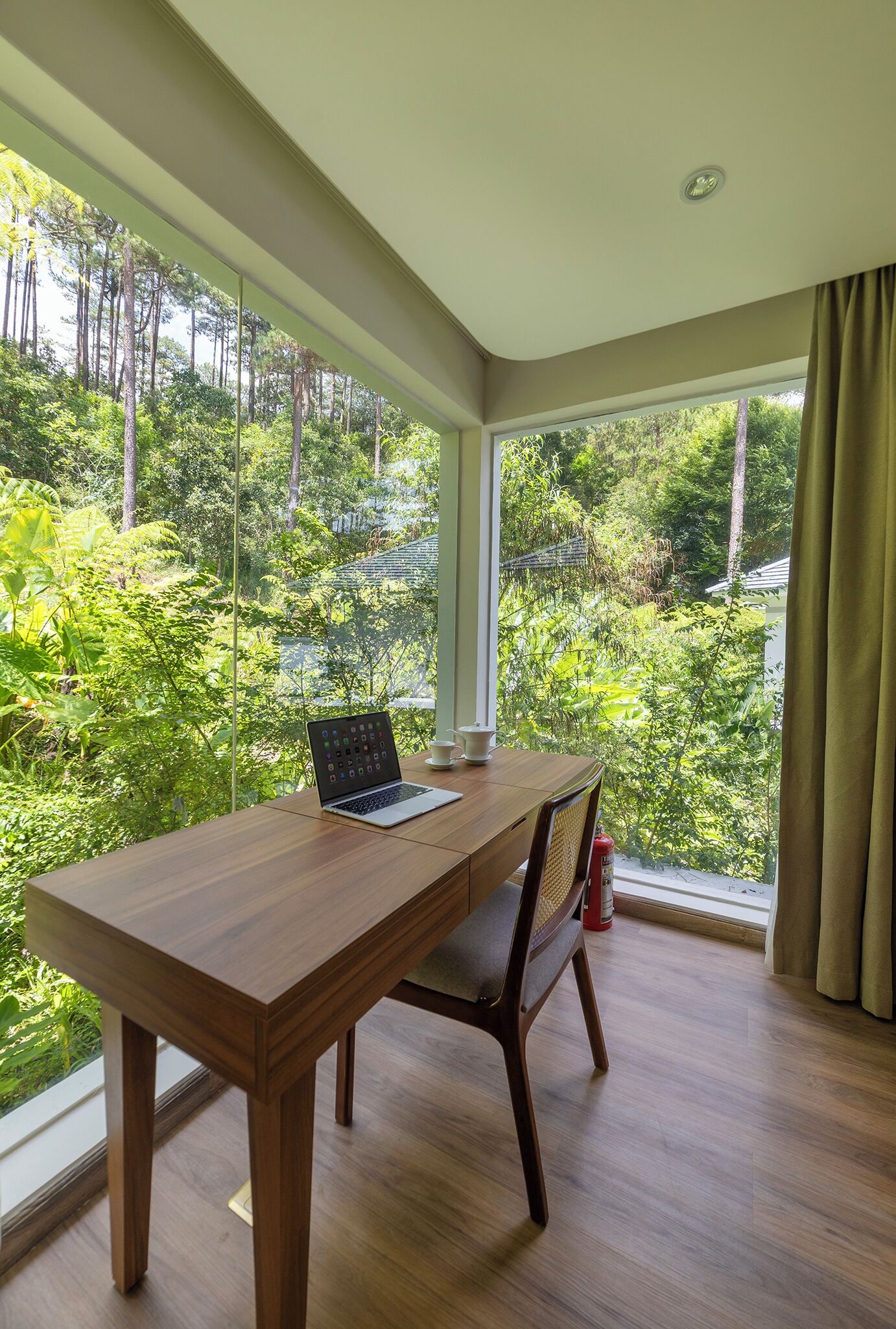Una habitación con una mesa de madera, una computadora portátil y una silla.