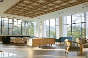 Amplia sala de estar con ventanas grandes, techo de madera y diversas opciones de asientos.