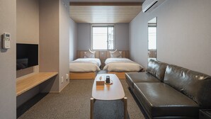 A compact hotel room with two beds, a sofa, a TV, and a small table. - GRAND BASE MIRAI (Nagasaki)