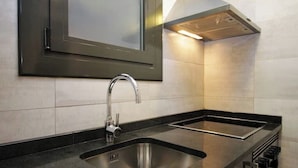 A modern kitchen with a stainless steel sink, a double oven, and a built-in range hood. - Spacious 2BR, quick access to Downtown (Barcelona)