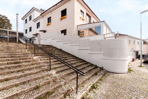 A staircase leading up to a building with a white facade and multiple windows. - Suite 302 — Aquedarte Lisbon (Lisboa)