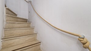 Un escalier avec une main courante en corde.