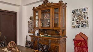 A dining room with a wooden cabinet, a table with chairs, and a wall with a photo collage. - Apartment 'Casa Valerio' with Sea View, Wi-Fi and Air Conditioning (Fiumefreddo di Sicilia)