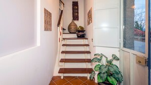 A staircase with wooden steps, a vase, and a potted plant. - Apartment 'Casa Valerio' with Sea View, Wi-Fi and Air Conditioning (Fiumefreddo di Sicilia)