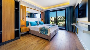 Ein modernes Hotelzimmer mit einem großen Bett, einem Kleiderschrank, einem Nachttisch, einem Fernseher und Blick auf die Stadt.