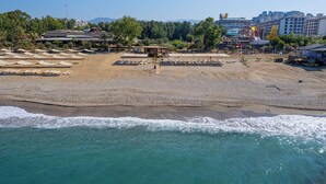 Ein Strand mit Liegestühlen und einem kleinen Gebäude, wahrscheinlich einer Strandhütte, in der Nähe des Wassers.