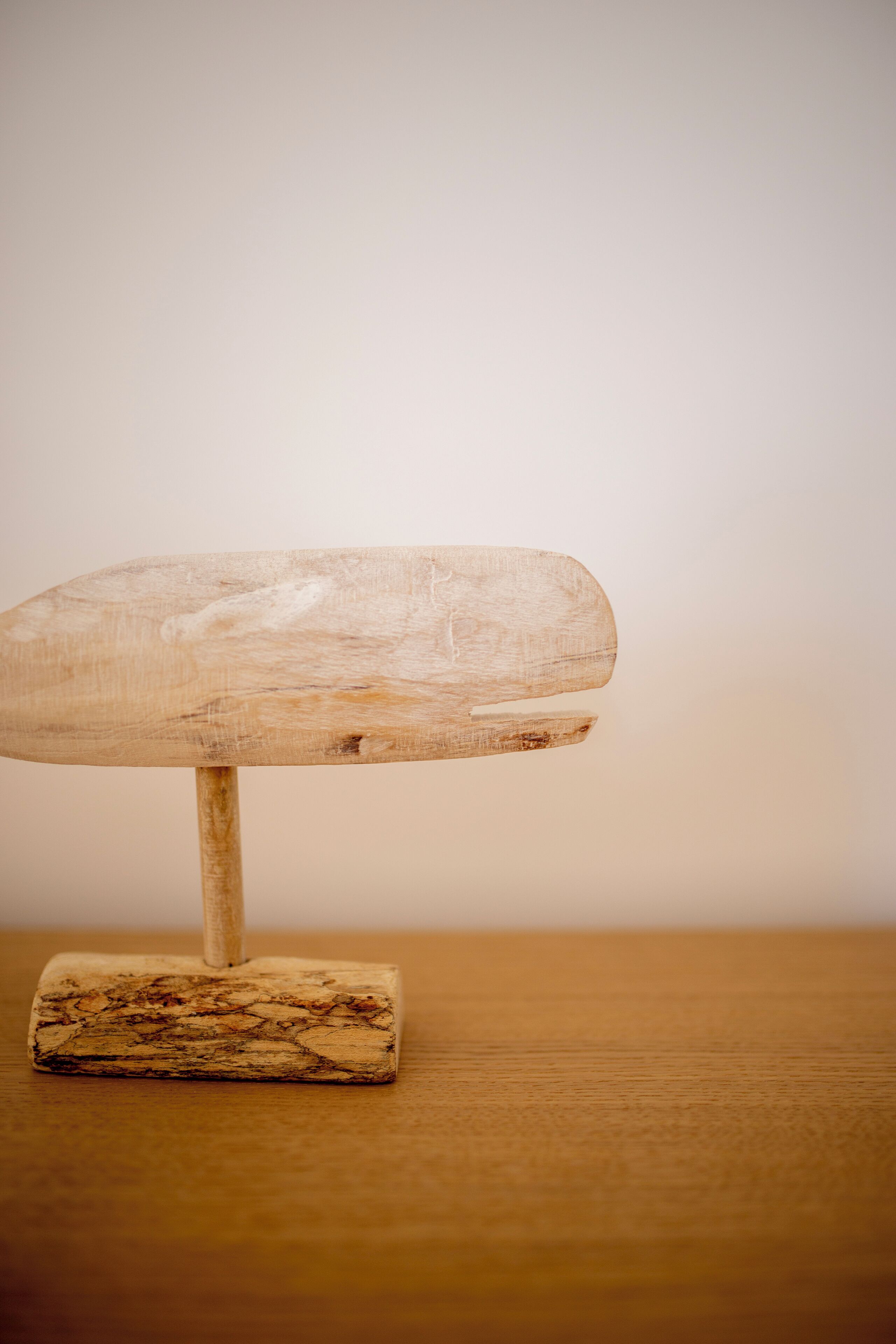 Una mesa de madera con superficie plana y una sola pata.