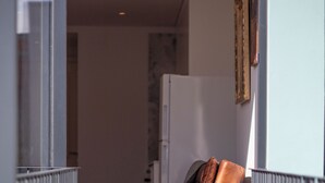 Ein modernes Wohnzimmer mit Ledersessel, Esstisch mit Untersetzer und einer Glastrennwand.