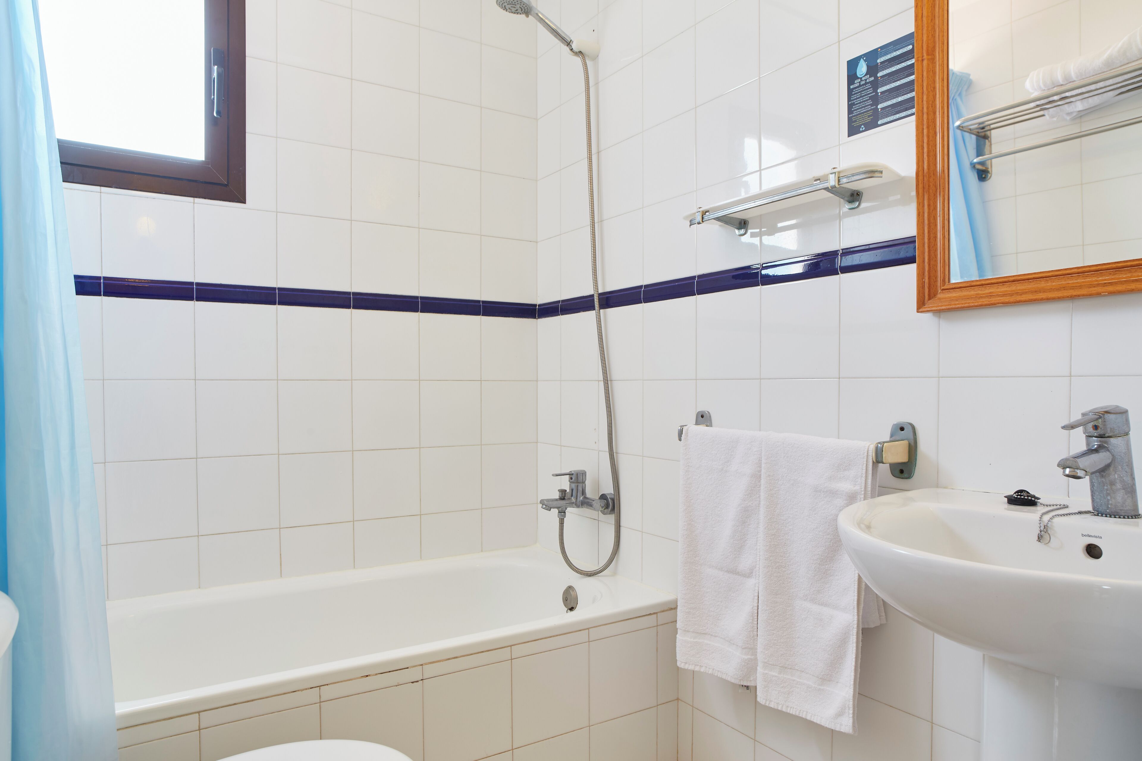 A bathroom with a bathtub, a sink, and a mirror.