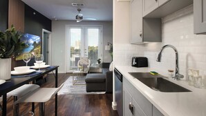 Eine moderne Küche mit weißer Arbeitsplatte, Spüle aus Edelstahl und Deckenventilator.