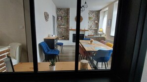 Ein Essbereich mit einem Holztisch, blauen Stühlen und einer Topfpflanze.