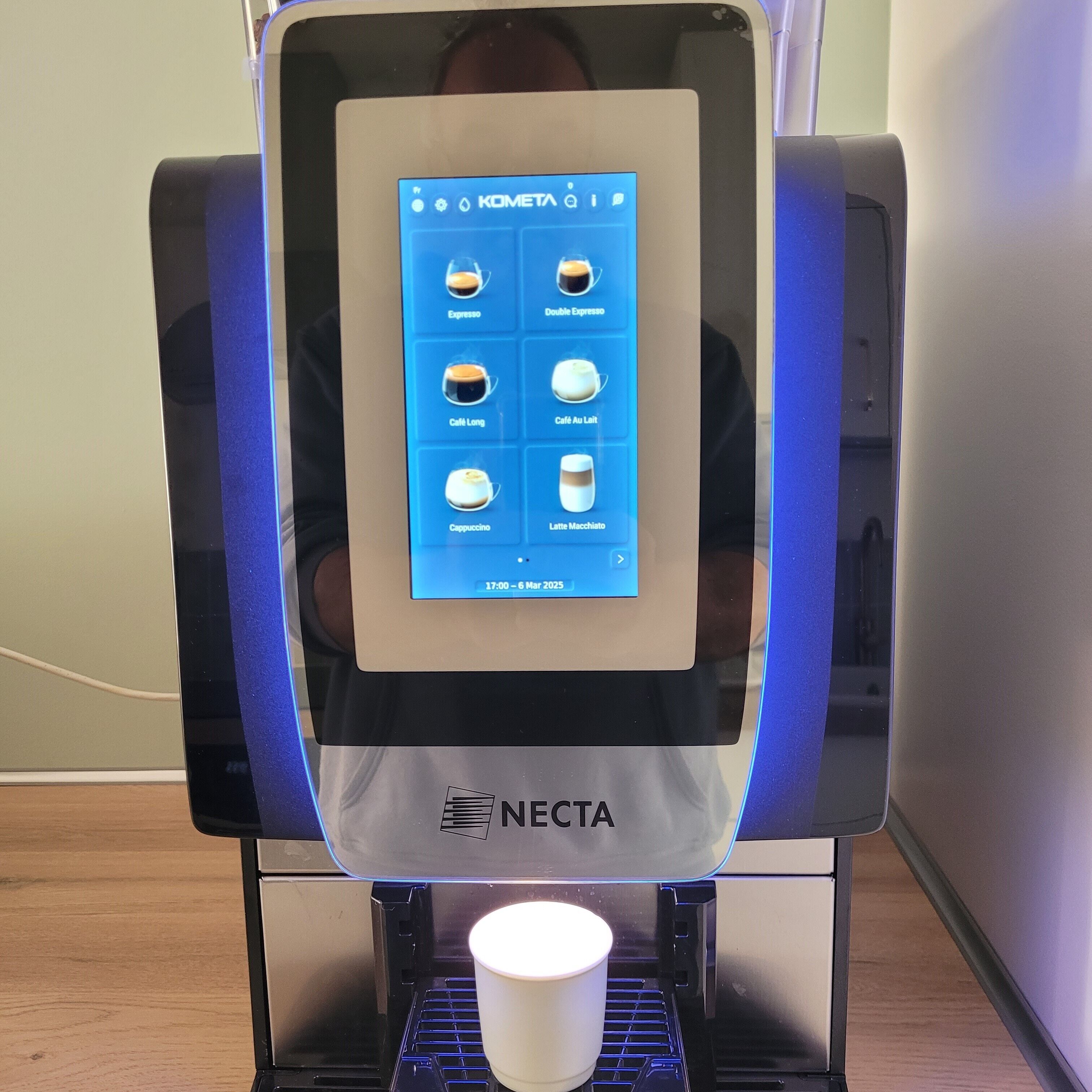 A coffee machine with a digital display menu, a cup holder, and the brand name 'NECTA' on the base.