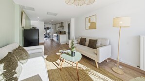 A modern living room with a sofa, a coffee table, a floor lamp, and a dining area in the background. - Chambre d'hôtes L'écrin fleuri  (Allerey-sur-Saone)