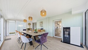 A modern kitchen with a dining area, wooden flooring, and a refrigerator. - Chambre d'hôtes L'écrin fleuri  (Allerey-sur-Saone)