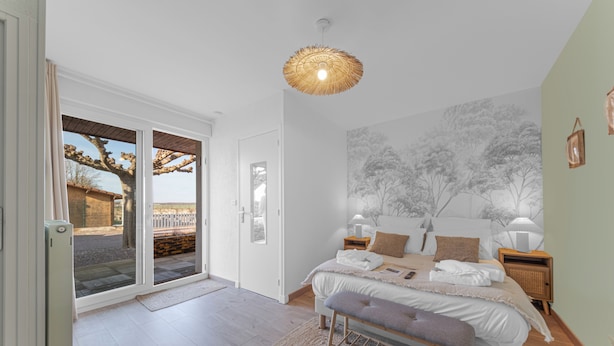 A bedroom with a bed, bedside tables, a bench, a door leading to an outdoor area, and a wall with a tree mural. - Chambre d'hôtes L'écrin fleuri  (Allerey-sur-Saone)