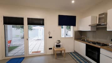 A modern kitchen with a gas stove, microwave, and a small table.