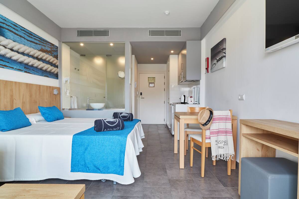 Une chambre d’hôtel moderne avec un grand lit, un bureau et une vue sur la cuisine.