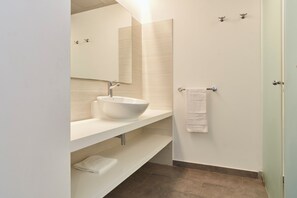 A modern bathroom with a white sink, mirror, and towel rack. - Invisa Aparthotel Casa Luis - New opening 2026 (Santa Eulalia del Rio)