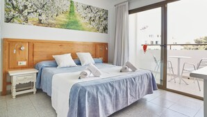 Een hotelkamer met een groot bed, een houten hoofdbord, een nachtkastje en een schilderij van een boom.