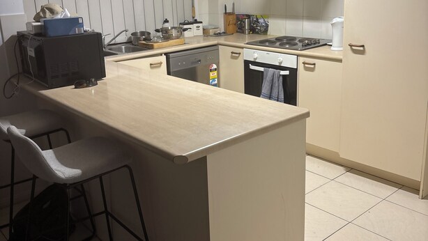 A kitchen with a large island, a dishwasher, a stove, and a sink. - Fantastic location townhouse close to beaches , shops , bus stop (Runaway Bay)