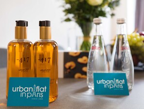 Zwei Flaschen Urban Flat Paris Parfüm und zwei Glasflaschen mit Etiketten stehen auf einem Tisch, vor ihnen liegt eine Karte.