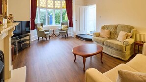 A living room with a fireplace, a sofa, a coffee table, and a TV. - Admiral’s Rest – Spacious - Historic Georgian Charm in the Heart of Broadstairs with Private Parking (Broadstairs)