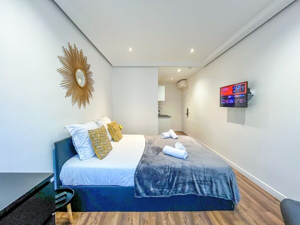 A modern hotel room with a bed, a TV, and a mirror. - UrbanFlat 209 - 249 Saint Denis SD1 (París)
