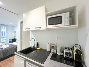A compact kitchen with a sink, a microwave, a kettle, and a toaster. - UrbanFlat 209 - 249 Saint Denis SD1 (París)