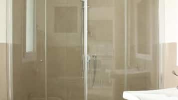 Regadera, secadora de cabello, toallas, papel de baño