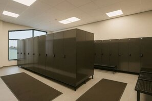 A locker room with metal lockers, a bench, and a large window providing natural light. - Central Lux Apartment D19 by Aavalevi (Levi)