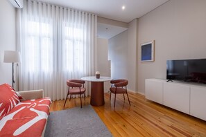 A modern living room with a sofa, a coffee table, two chairs, a TV, and a white cabinet. - Braga Essence Apartment By Minhos Guest (Braga)