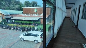 A corridor with a parked car and a building with a sign in a foreign language. - BR Comfort (Bengaluru)